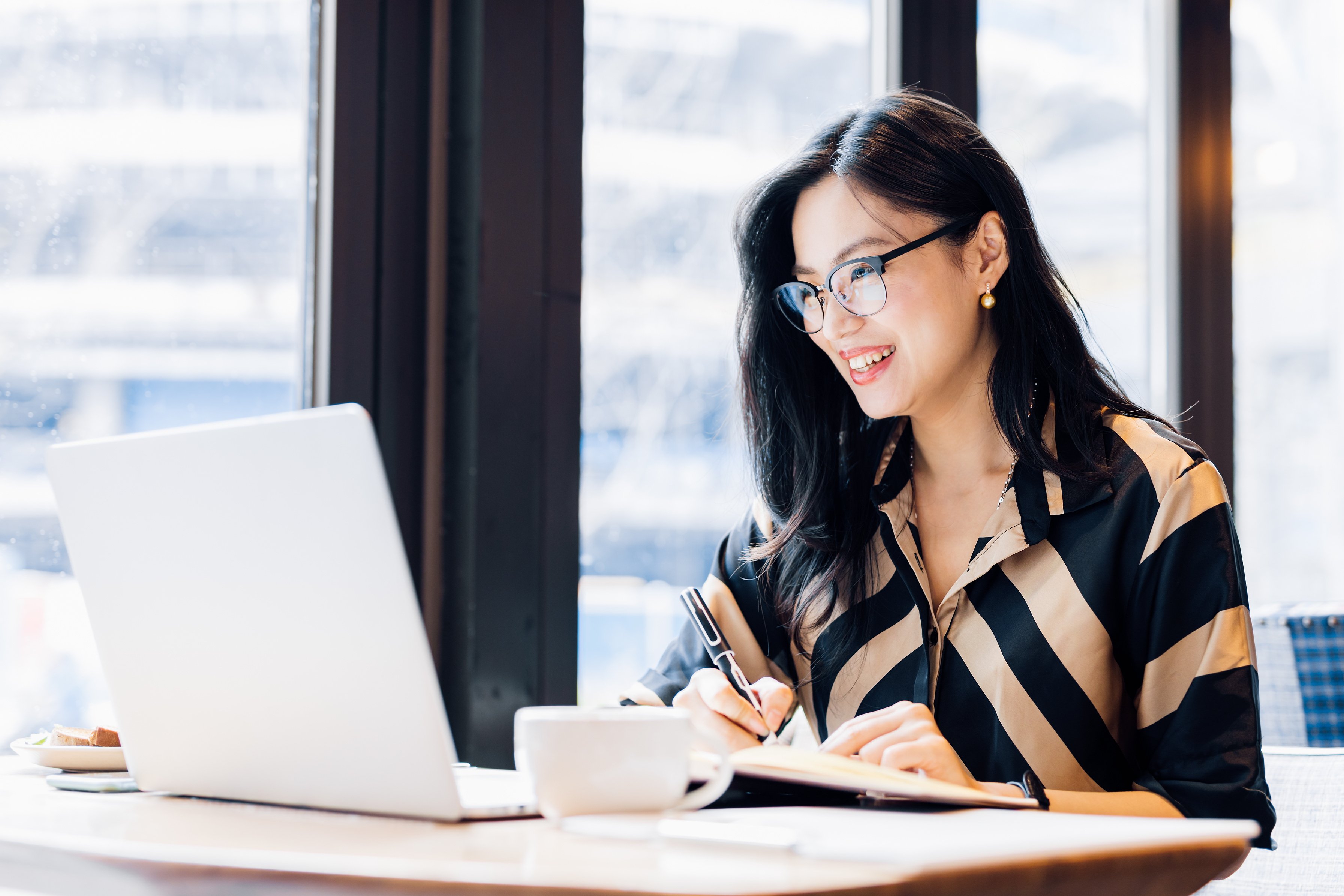 Asian woman working laptop at cafe.